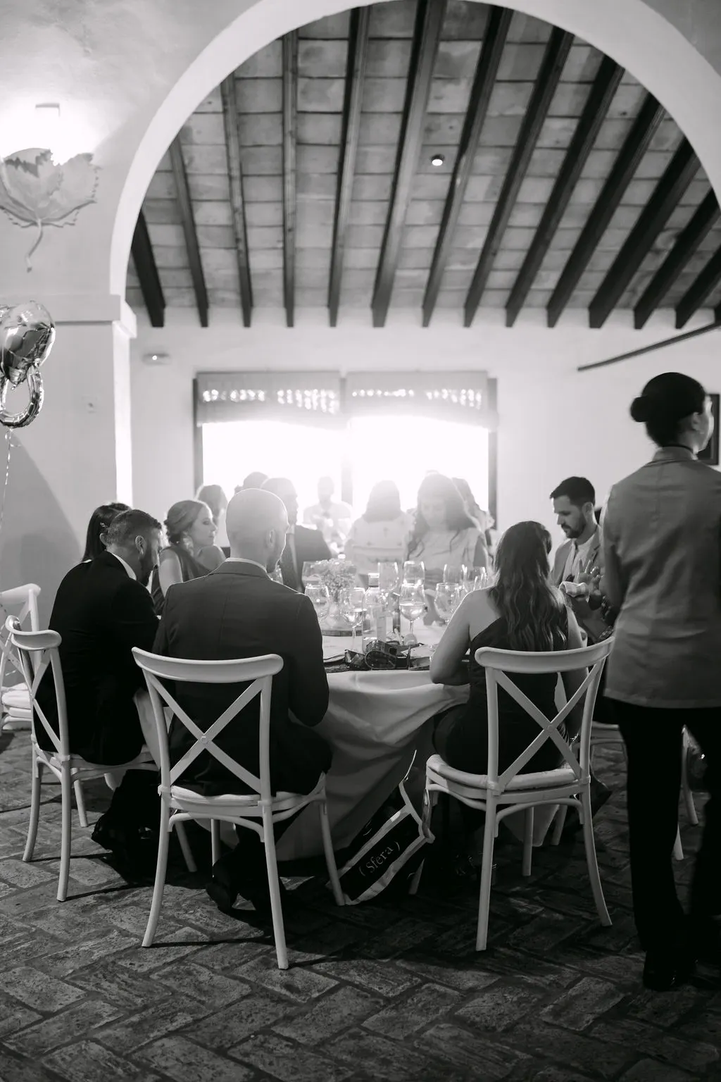 Invitados durante el banquete bajo los arcos de Bodegas Barbadillo, en blanco y negro