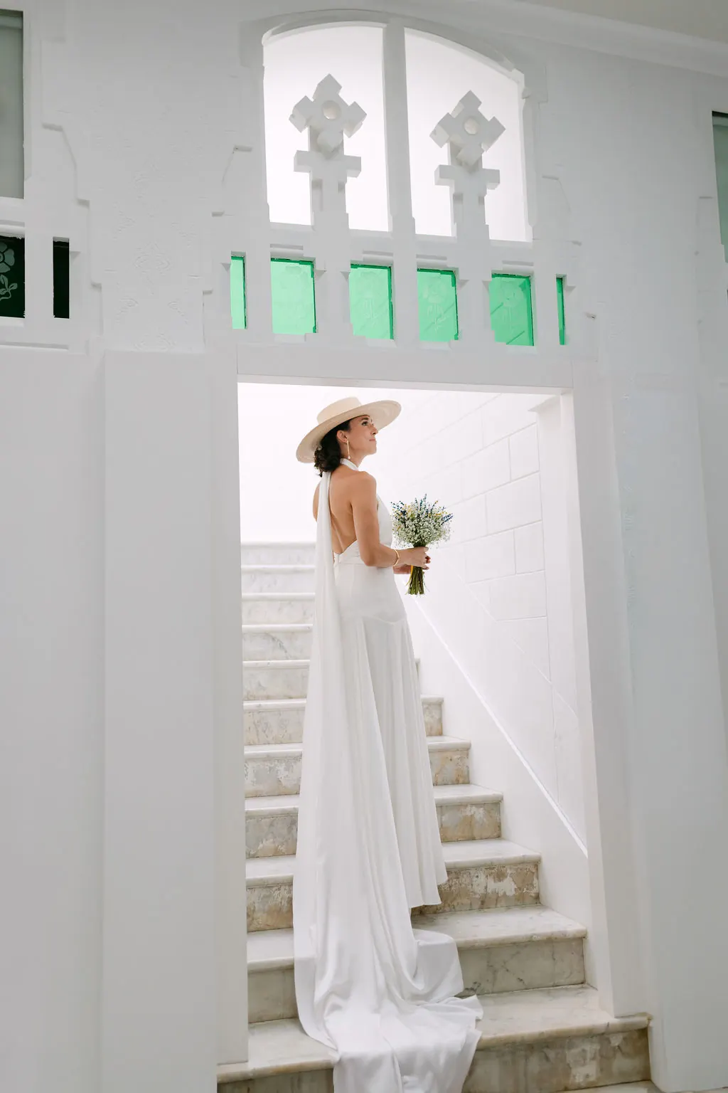 Retrato de MªCarmen con ramo y sombrero en una escalera blanca