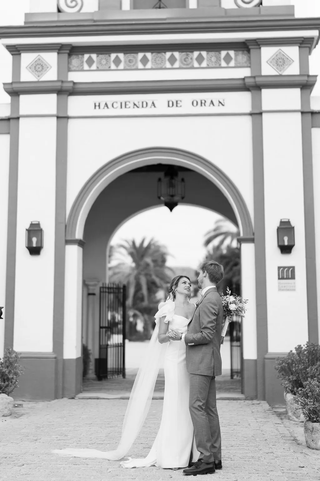 Julia y Paul bajo la portada de Hacienda de Orán, en blanco y negro