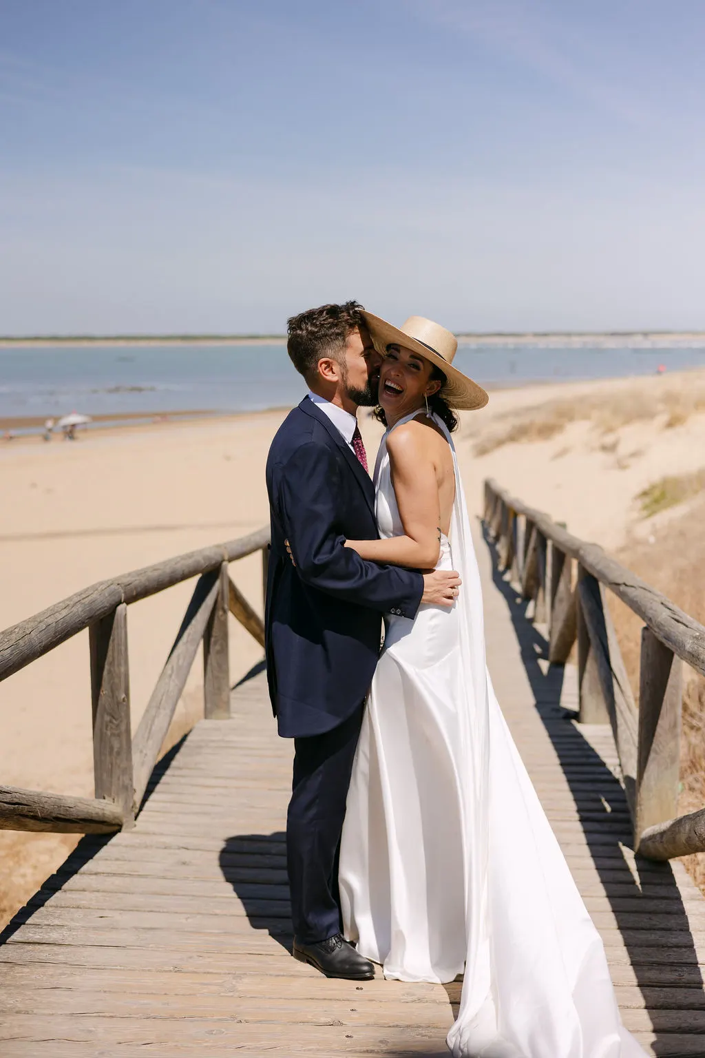 MªCarmen y Jose Miguel riendo abrazados en la pasarela de la playa de Sanlúcar de Barrameda