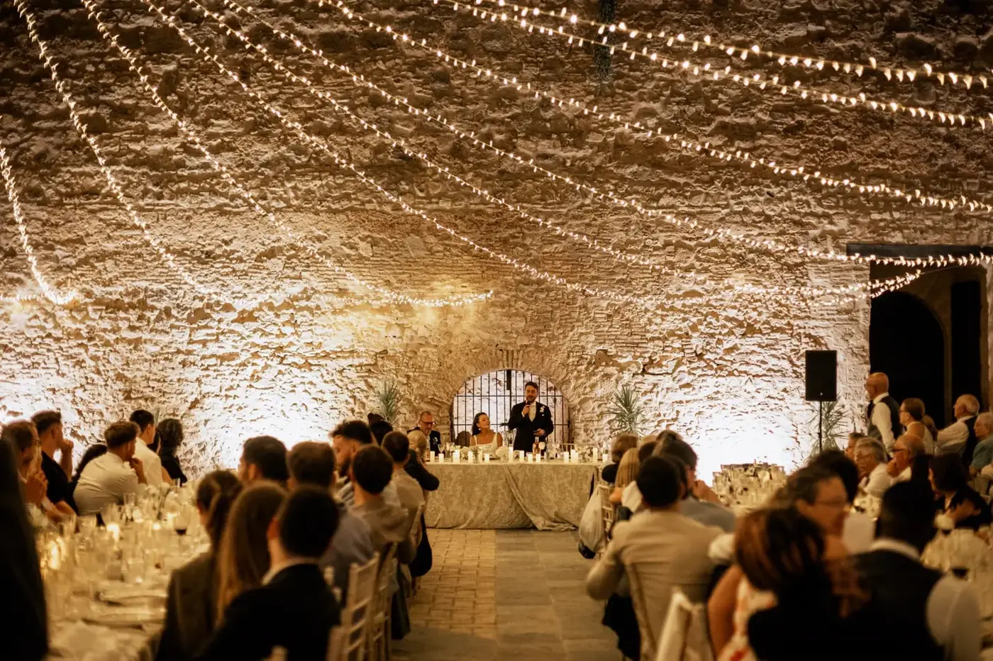 Discurso en el salón del castillo bajo un cielo de guirnaldas de luces