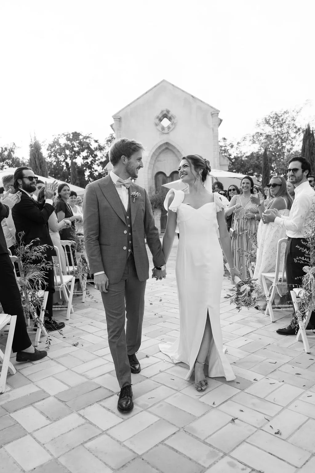 Julia y Paul saliendo de la ceremonia de la mano frente a la capilla de Hacienda de Orán