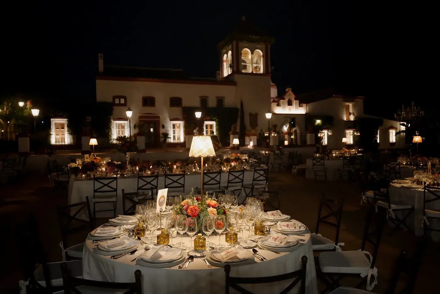Mesa de la cena frente a la fachada iluminada de Hacienda Orán