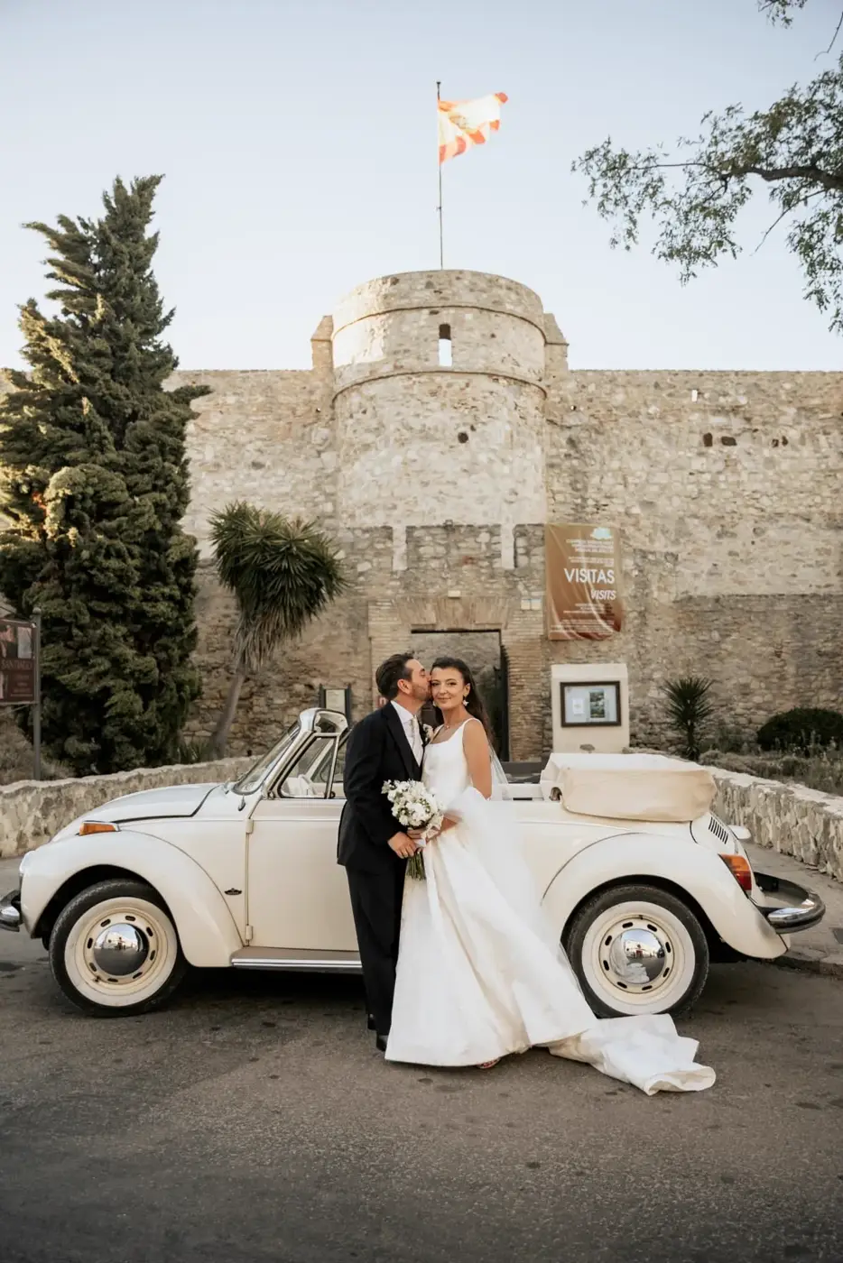 Rhianna y Javier junto al coche clásico frente al Castillo de Santiago