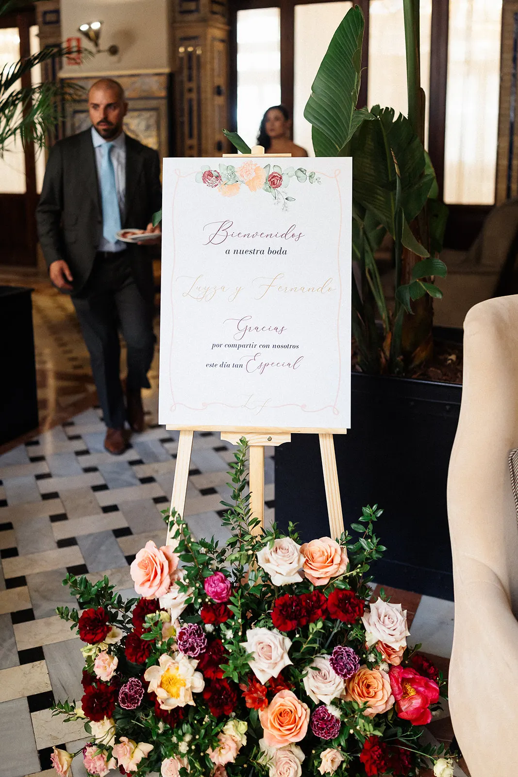 Cartel de bienvenida de Luyza y Fernando con flores en el Hotel Alfonso XIII