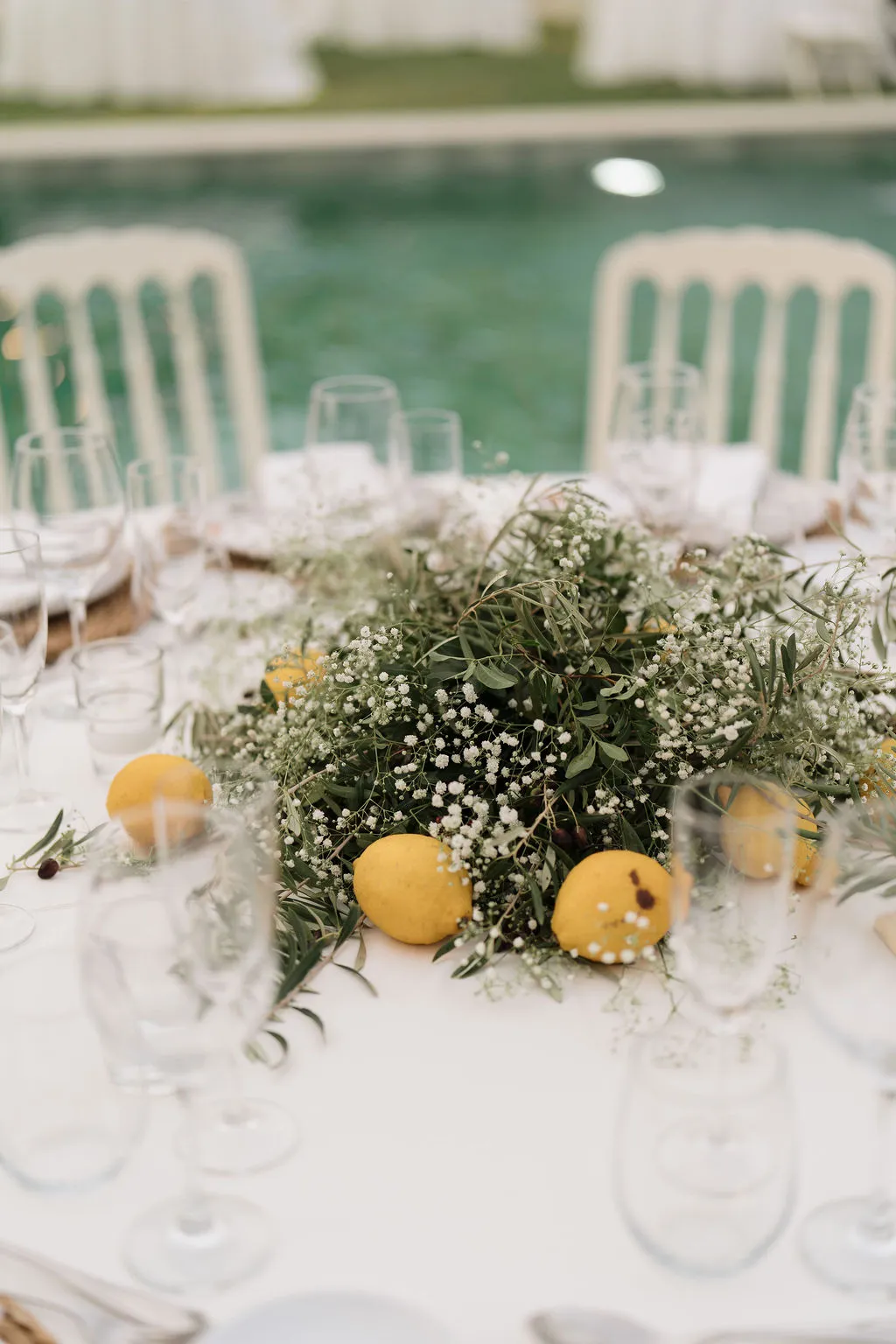 Centro de mesa con olivo, paniculata y limones junto a la piscina