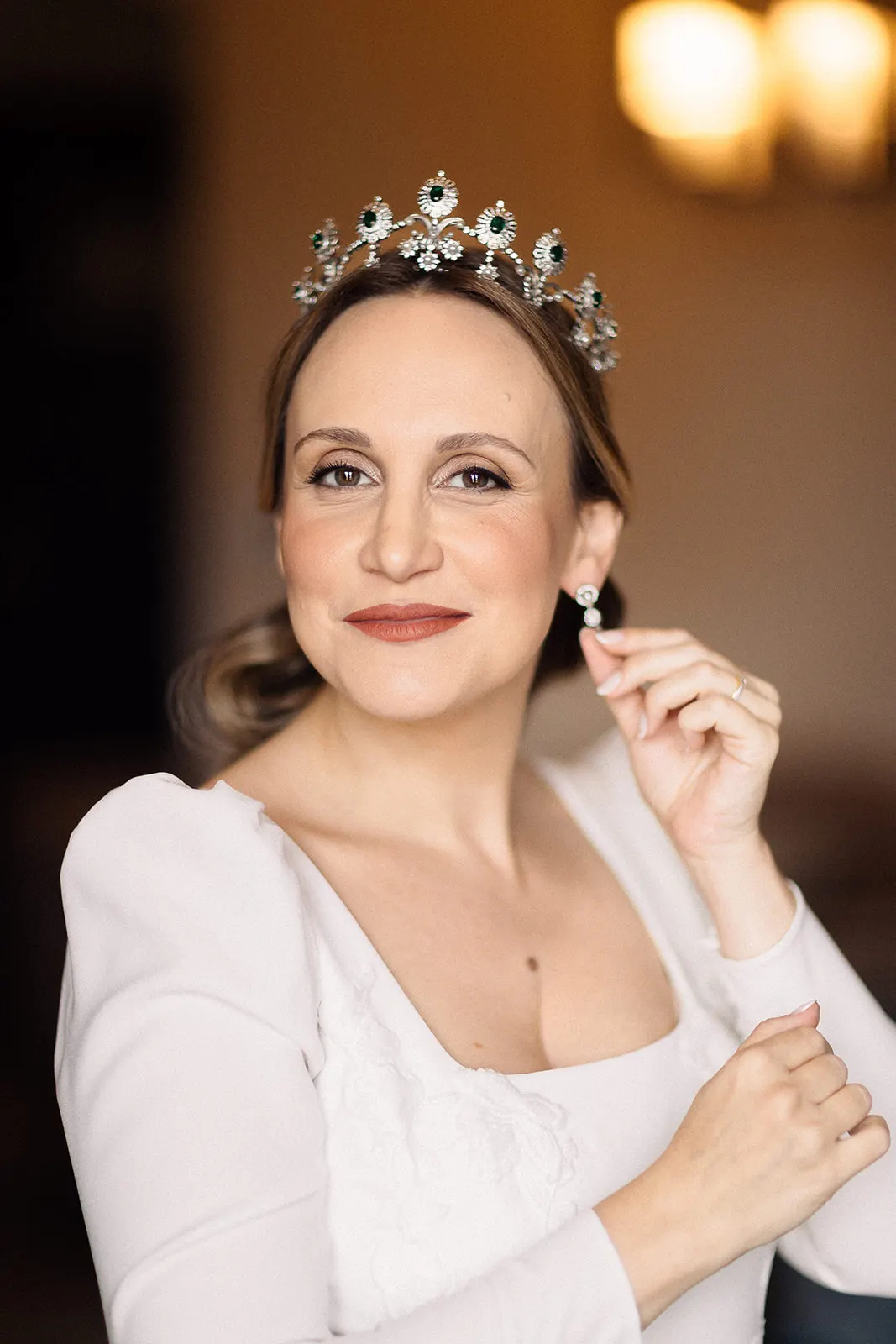 Luyza con su tiara colocándose los pendientes antes de la boda