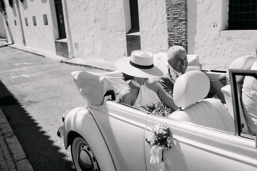 MªCarmen llegando en un coche clásico acompañada por su padre, en blanco y negro