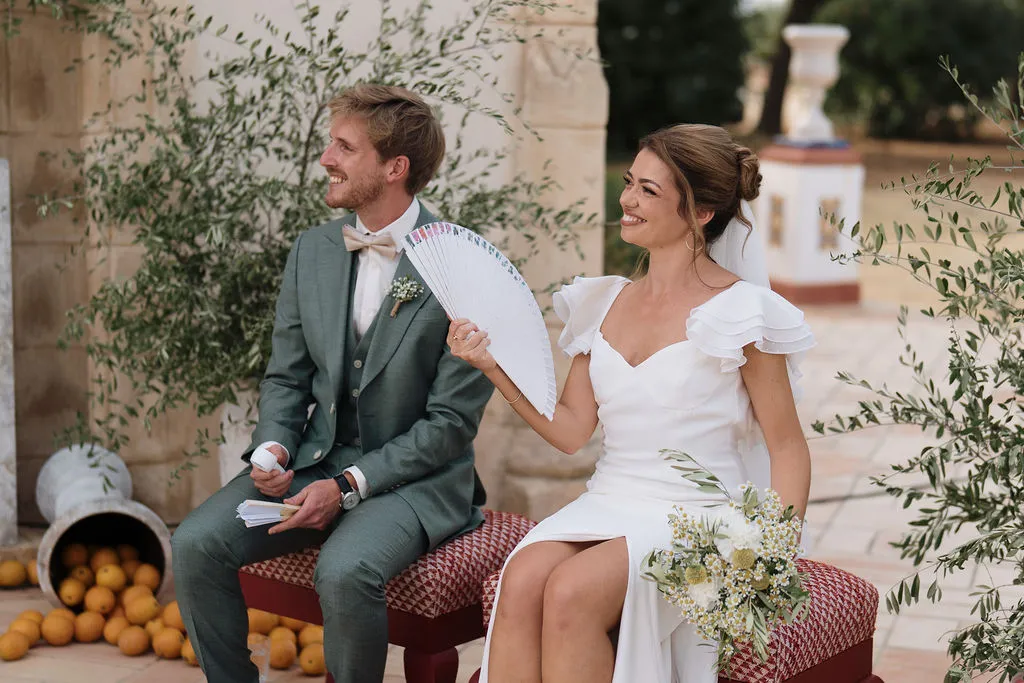 Julia y Paul sonriendo durante la ceremonia con abanico en Hacienda de Orán
