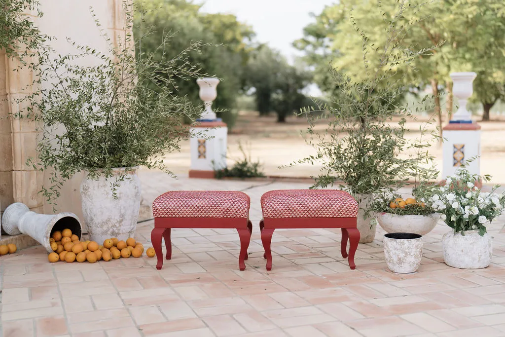 Montaje de ceremonia con olivos, naranjas y bancos rojos en Hacienda de Orán