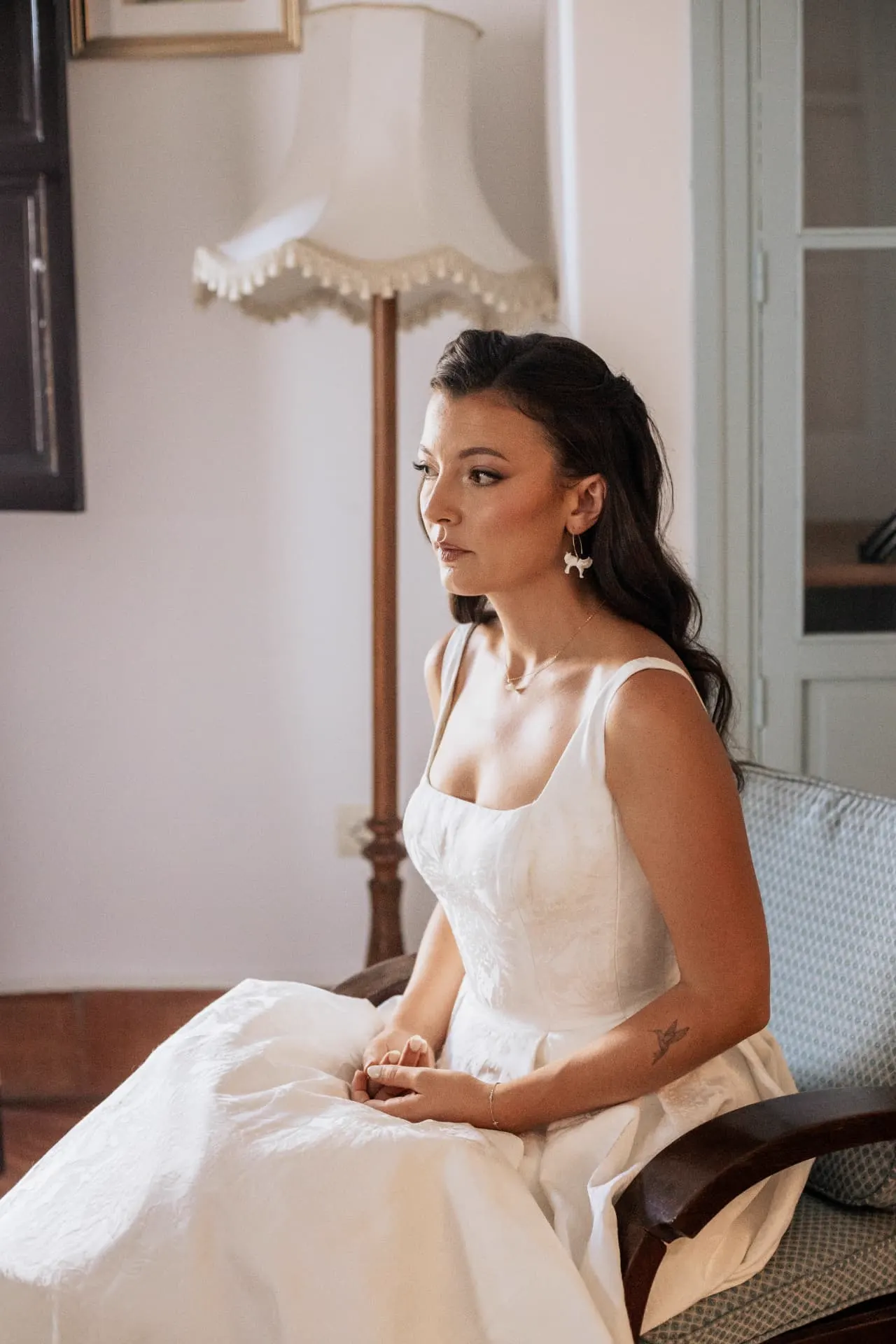 Rhianna sentada con su vestido de novia junto a la ventana