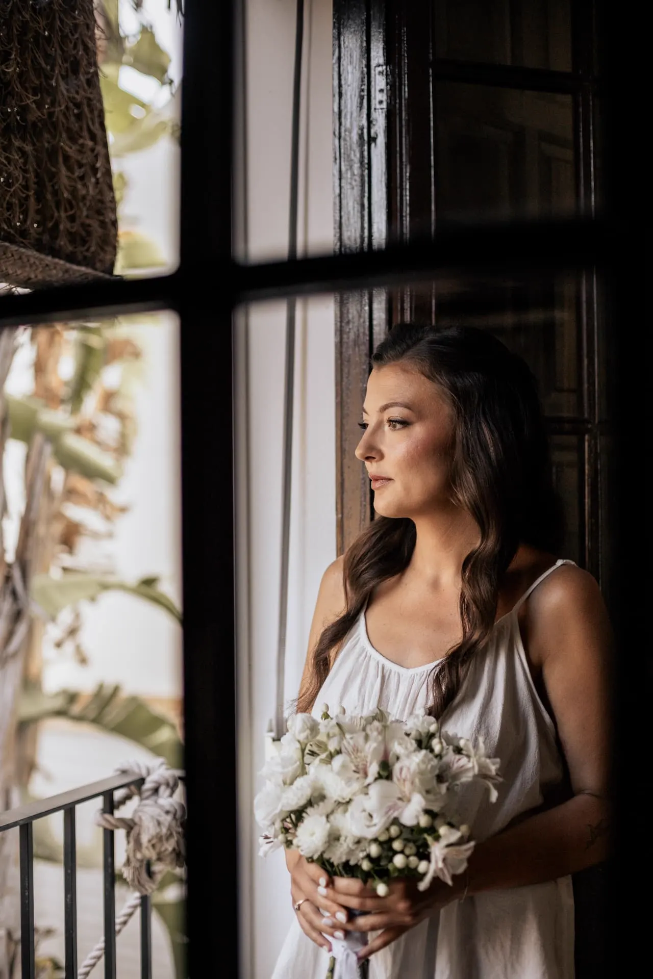 Rhianna junto a la ventana con su ramo de novia