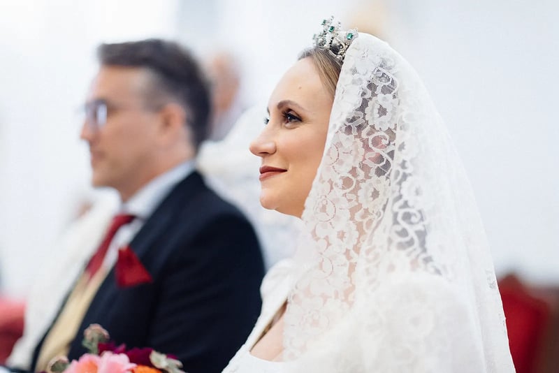 Luyza con mantilla y tiara durante la ceremonia, con Fernando a su lado – boda organizada por Greta Weddings