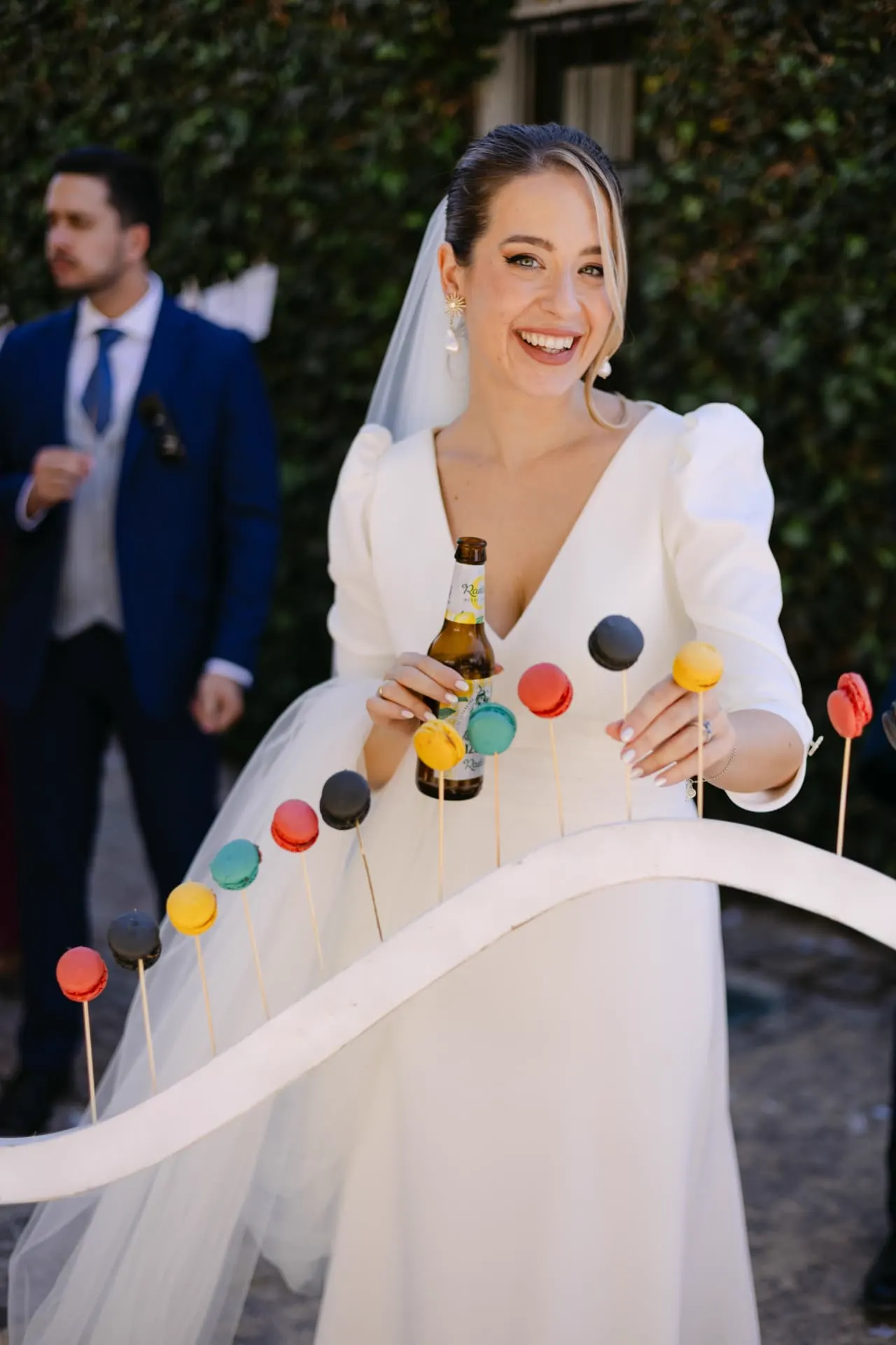 Aisha riendo junto al expositor de macarons durante el aperitivo
