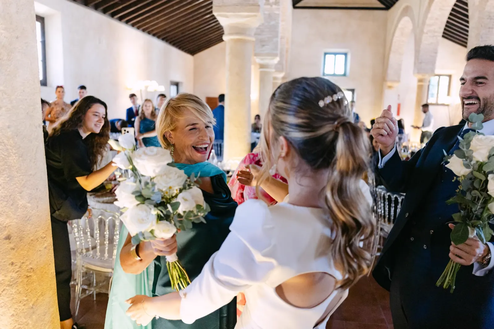 Aisha abrazando a una invitada a la entrada del salón del banquete