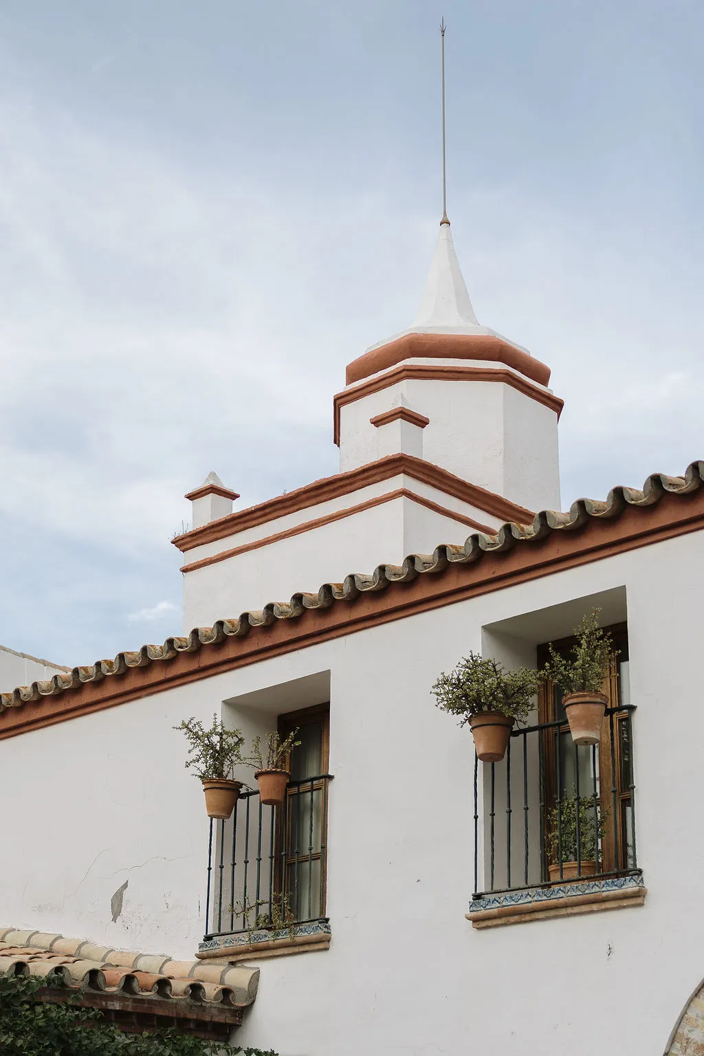 Torre encalada de Hacienda de Orán con macetas en las ventanas