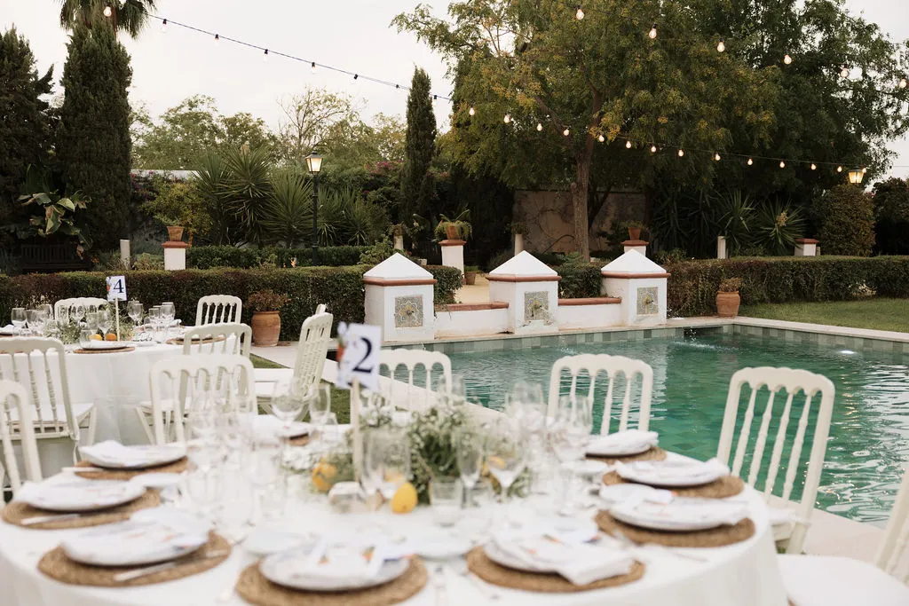 Mesas del banquete junto a la piscina al atardecer en Hacienda de Orán