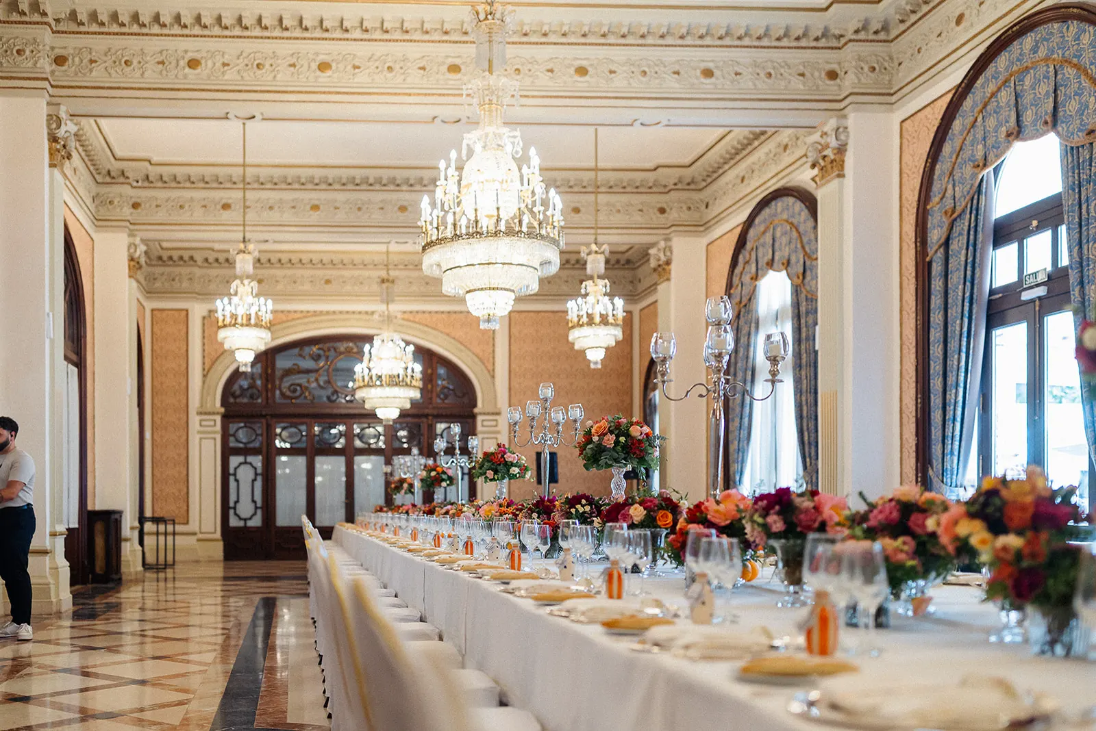 Salón del Hotel Alfonso XIII con lámparas de araña y la mesa del banquete montada