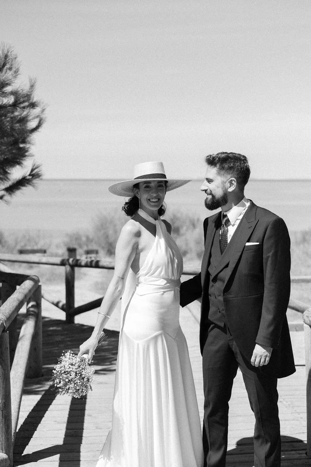 MªCarmen con su ramo y Jose Miguel paseando junto al mar, en blanco y negro