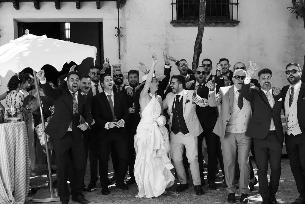 MªCarmen celebrando con todos los invitados en el patio de Bodegas Barbadillo, en blanco y negro