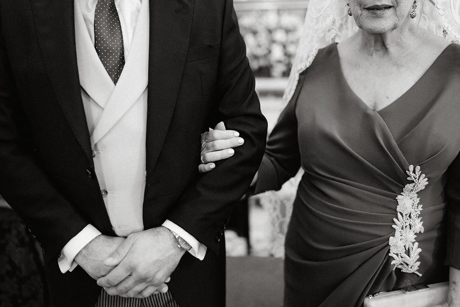 Fernando del brazo de su madre con mantilla al entrar a la iglesia, en blanco y negro