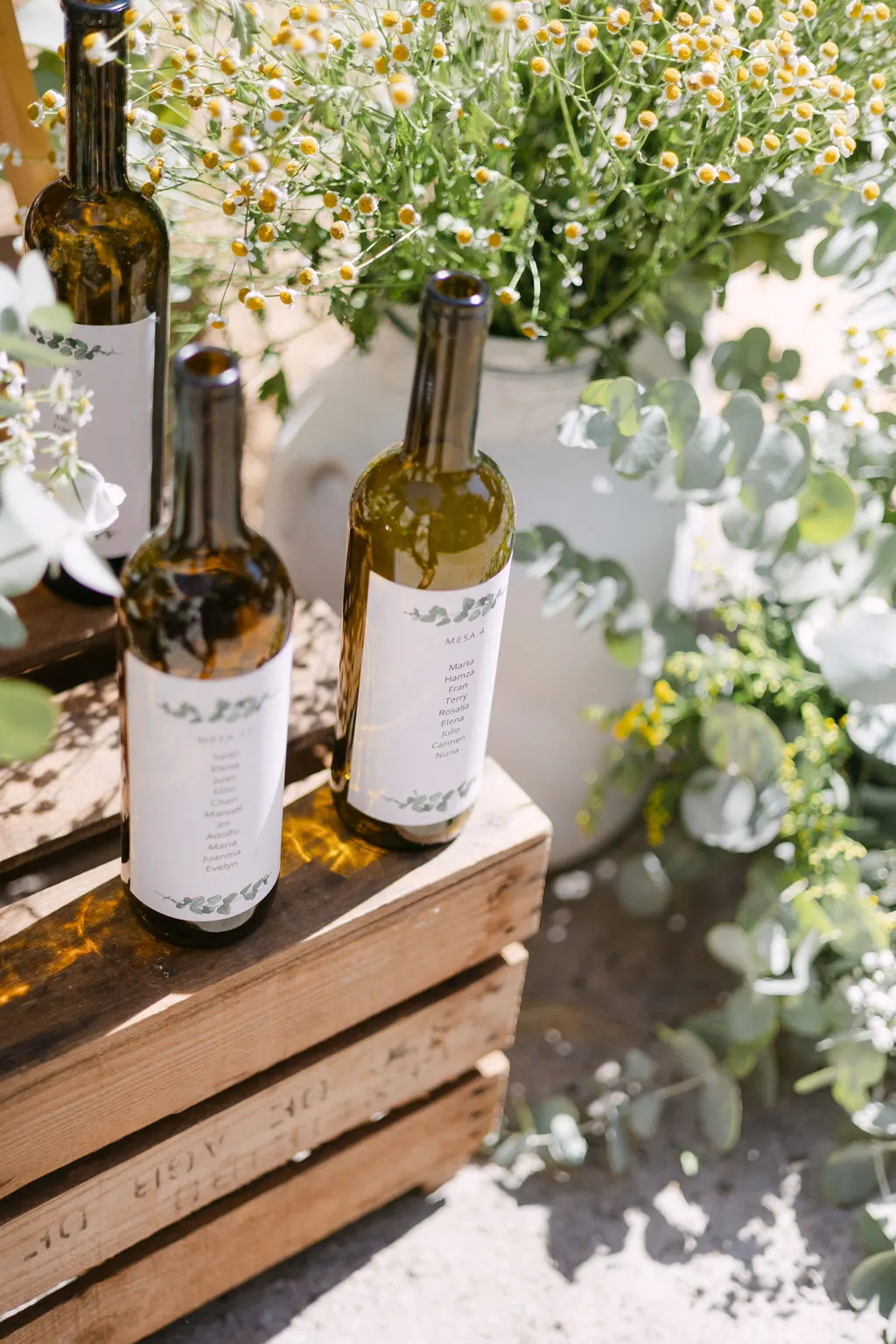 Seating plan con botellas etiquetadas y flores silvestres en Bodegas Barbadillo