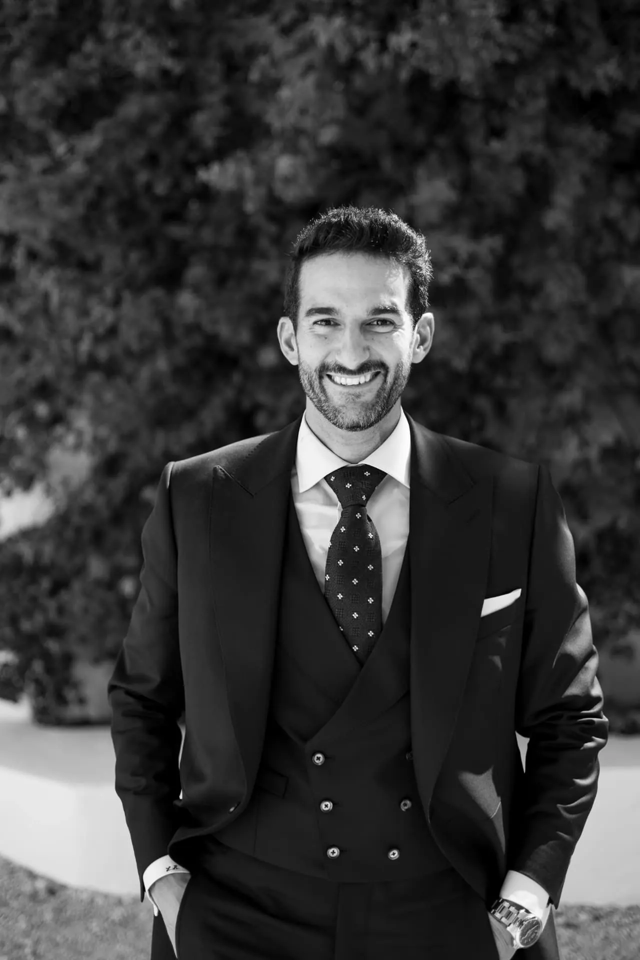 Retrato en blanco y negro de Luis sonriendo con su traje de tres piezas