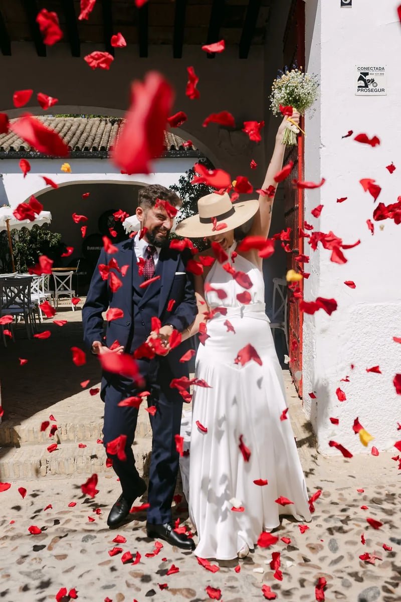MªCarmen y Jose Miguel saliendo entre pétalos rojos en Bodegas Barbadillo – boda organizada por Greta Weddings
