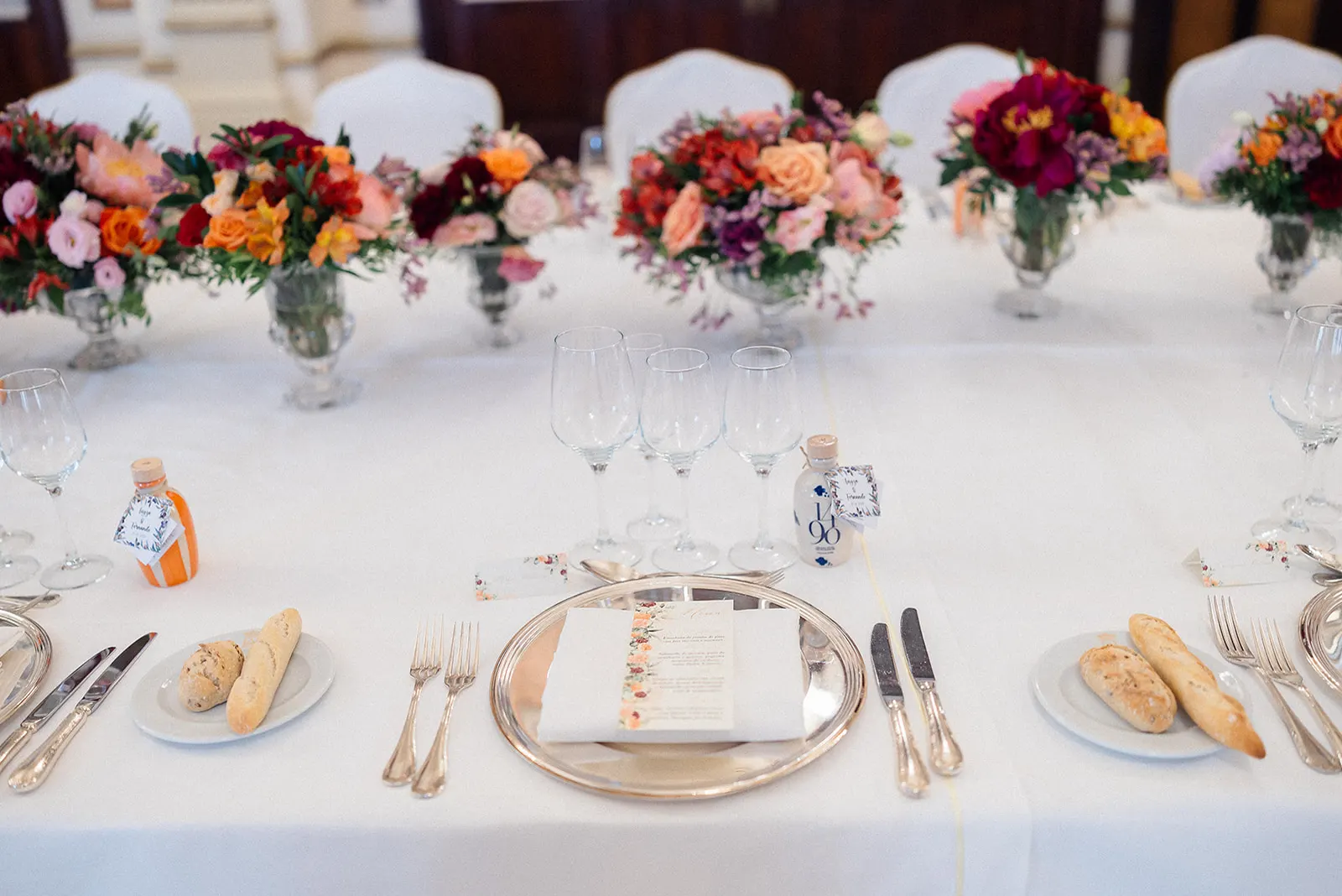 Detalle del cubierto con minuta floral, cristalería y detalle para los invitados