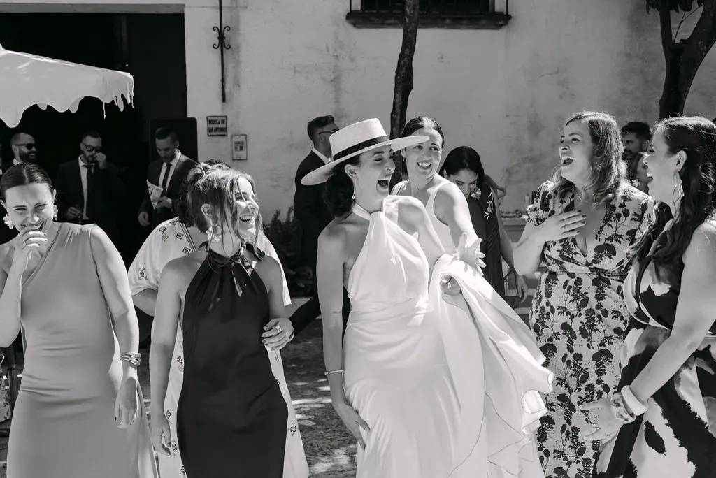 MªCarmen riendo con sus amigas durante la celebración, en blanco y negro