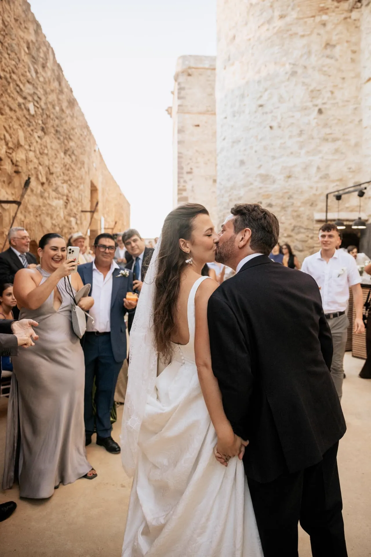 Rhianna y Javier besándose rodeados de sus invitados en el castillo